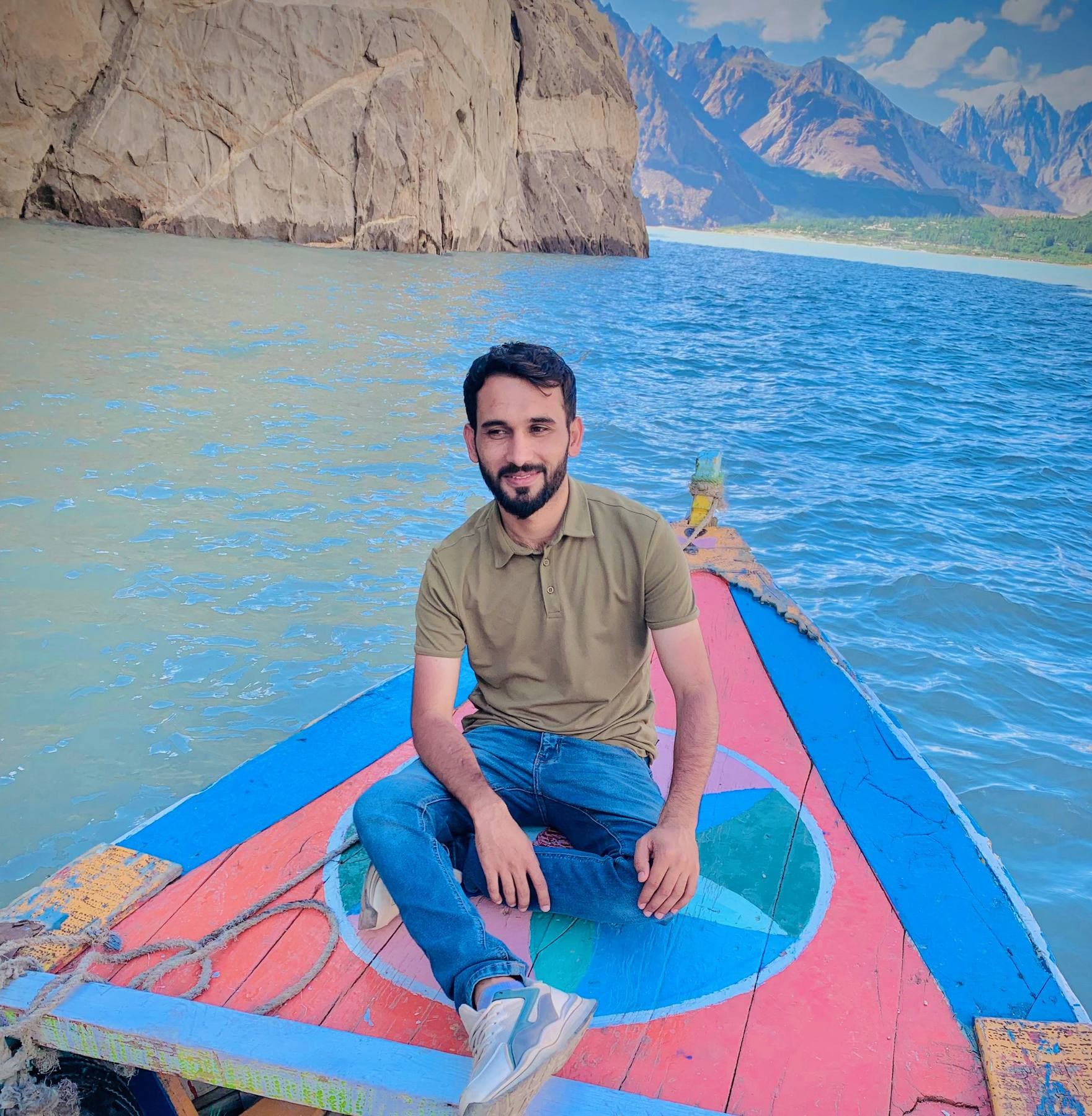 A boat-ride photo op, painted peaks standing in for the real ones.
