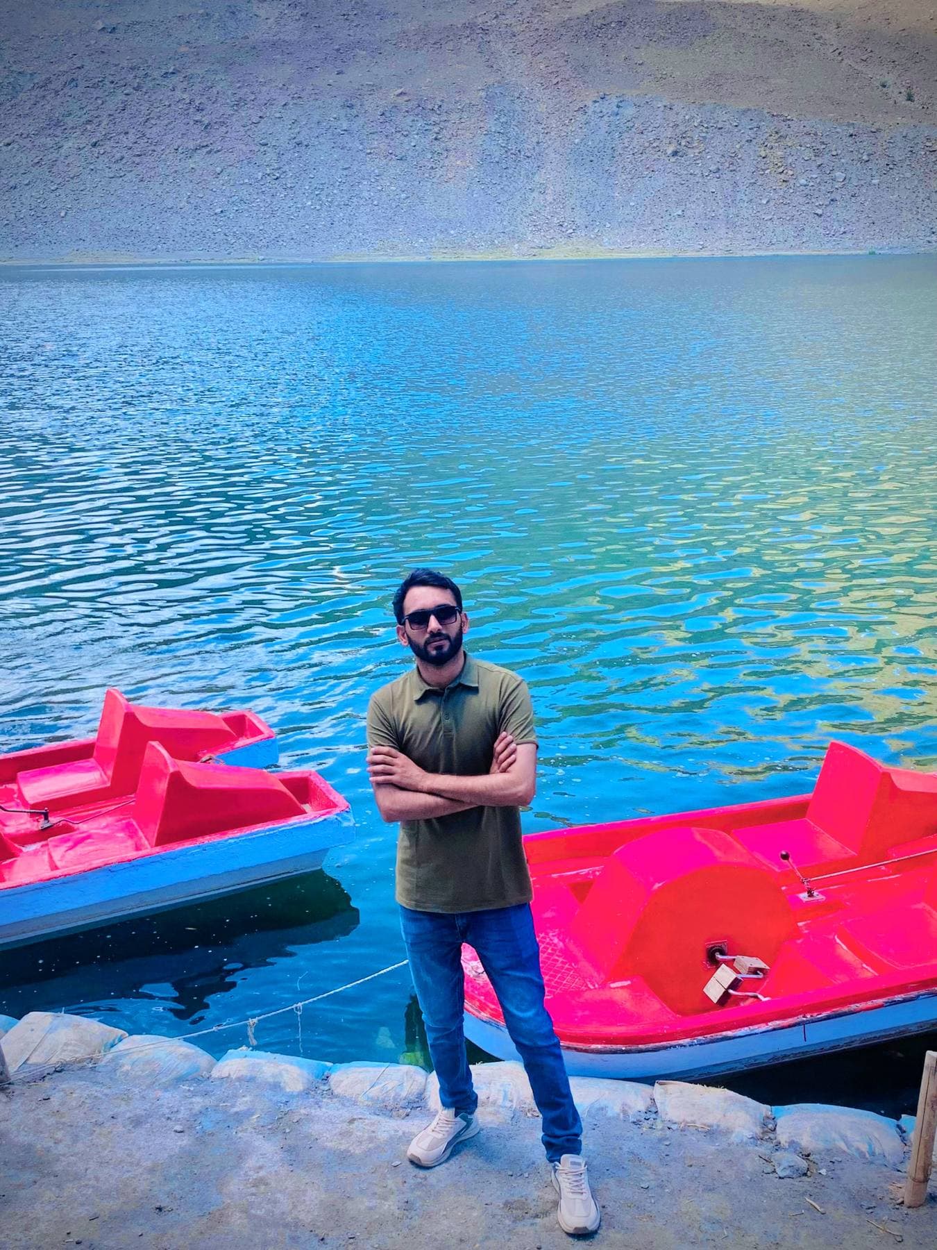 Paddle boats pulled up on a glacial lake, water gone impossibly blue.