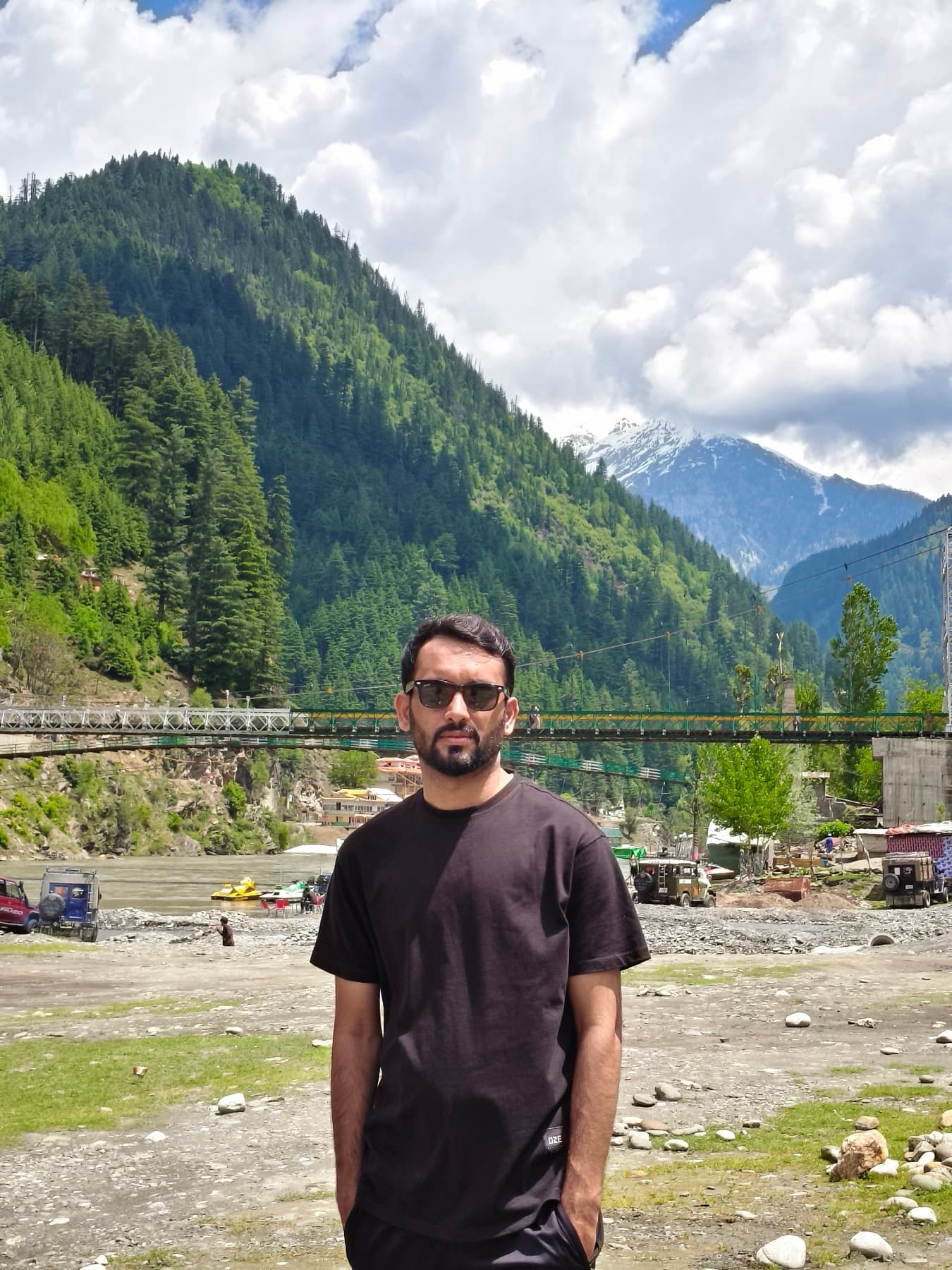 Crossing point over a glacier-fed river, footbridge in the background.